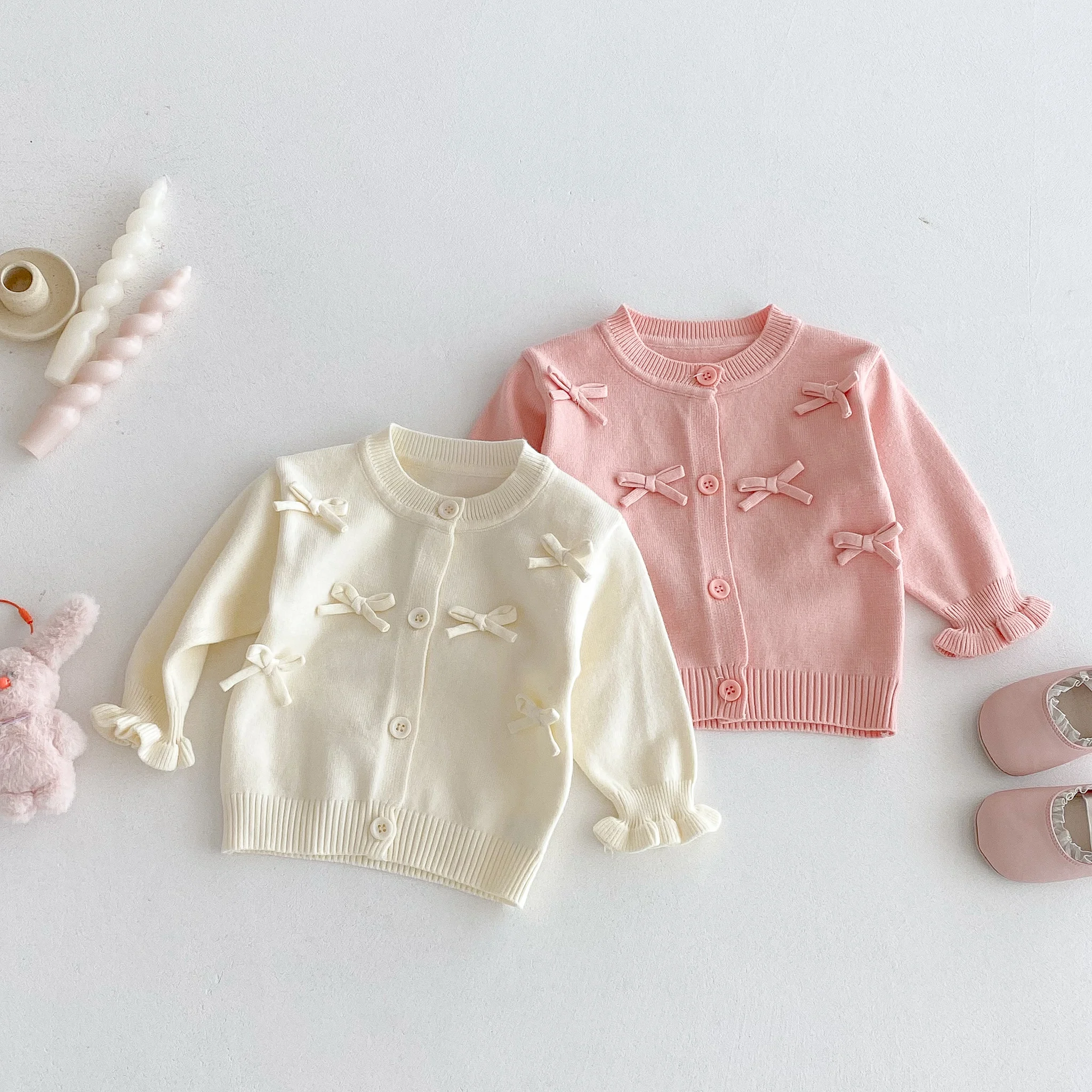 Un simpatico cardigan a maniche lunghe con fiocco per una bambina in autunno