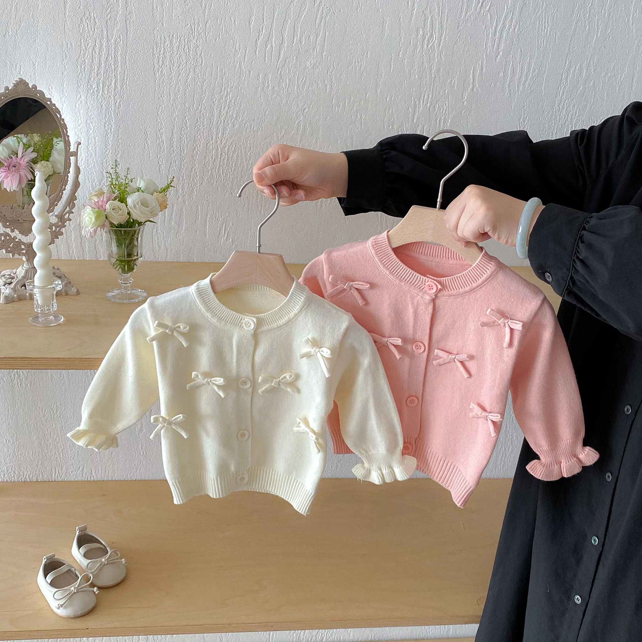 Un simpatico cardigan a maniche lunghe con fiocco per una bambina in autunno