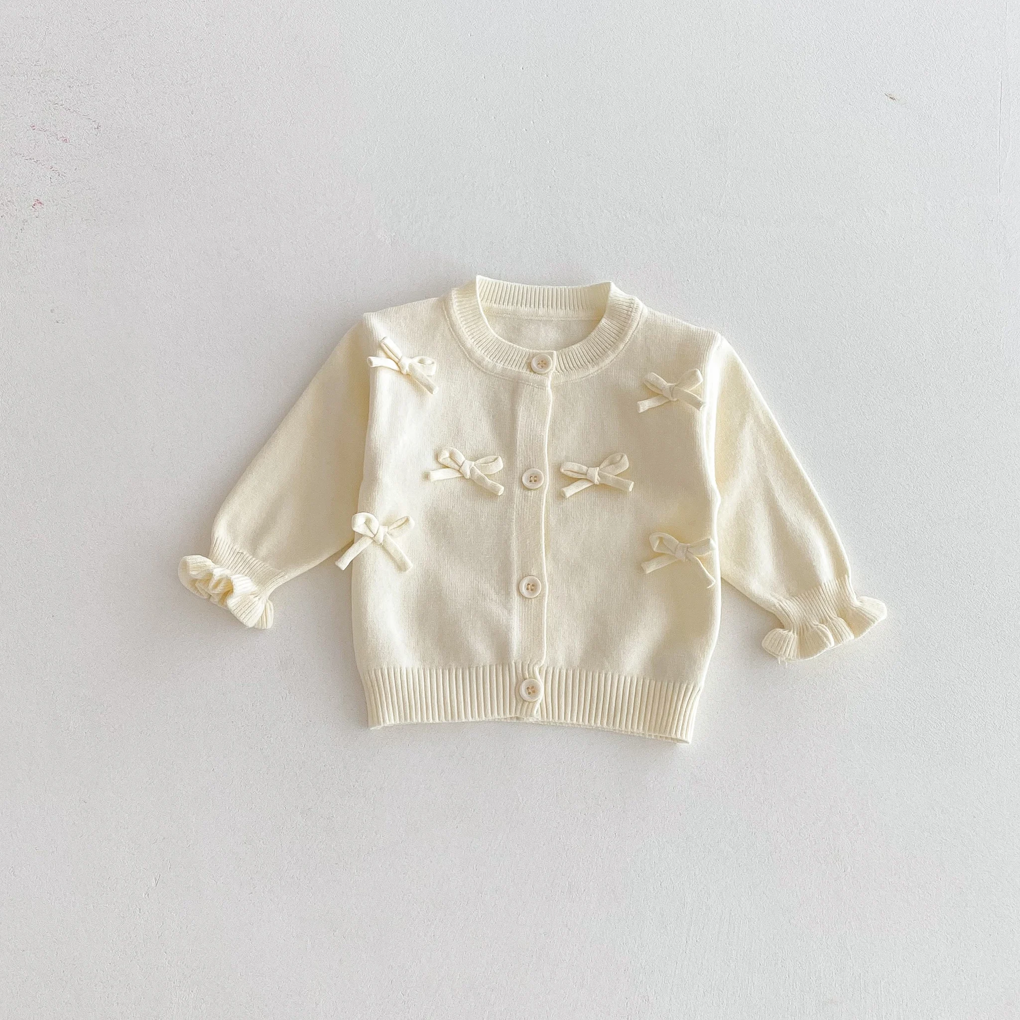 Un simpatico cardigan a maniche lunghe con fiocco per una bambina in autunno
