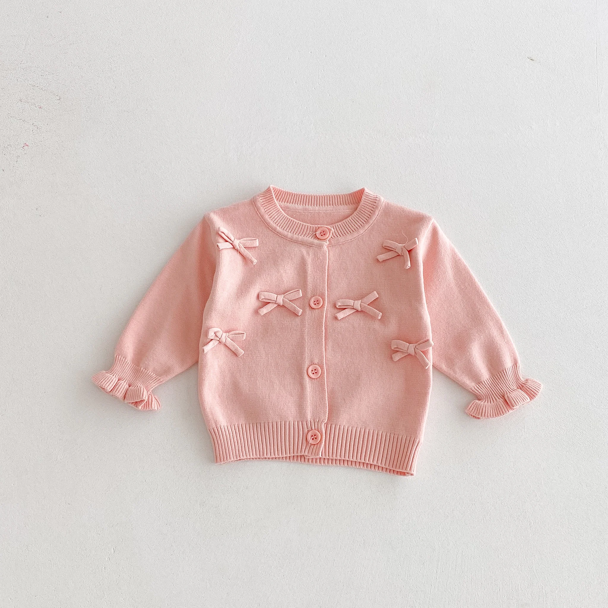Un simpatico cardigan a maniche lunghe con fiocco per una bambina in autunno